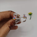 silver toe ring featuring two circular colorful inlays with red, orange, and blue details
