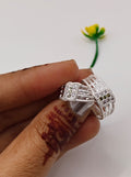 silver toe ring with intricate filigree and small clear stones