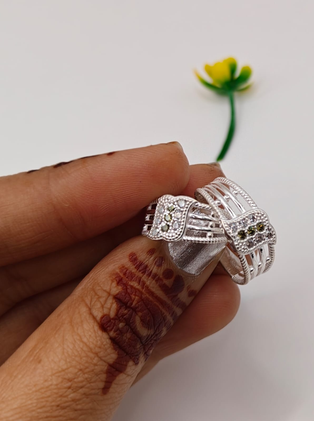 silver toe ring with intricate filigree and small clear stones