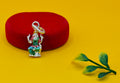A small silver-toned deity charm with colorful green, red, and gold enamel Lakshmi