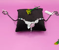 A silver-toned mangalsutra with a decorative pendant featuring a silver leaf and a pink heart-shaped stone