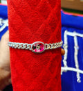 silver chain bracelet with a round pink charm featuring a black Mickey Mouse