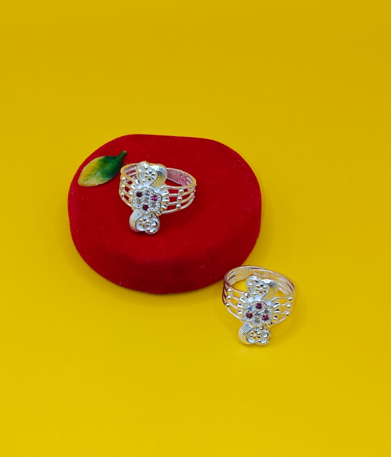 Two silver-toned toe rings with floral  set with small red and clear stones